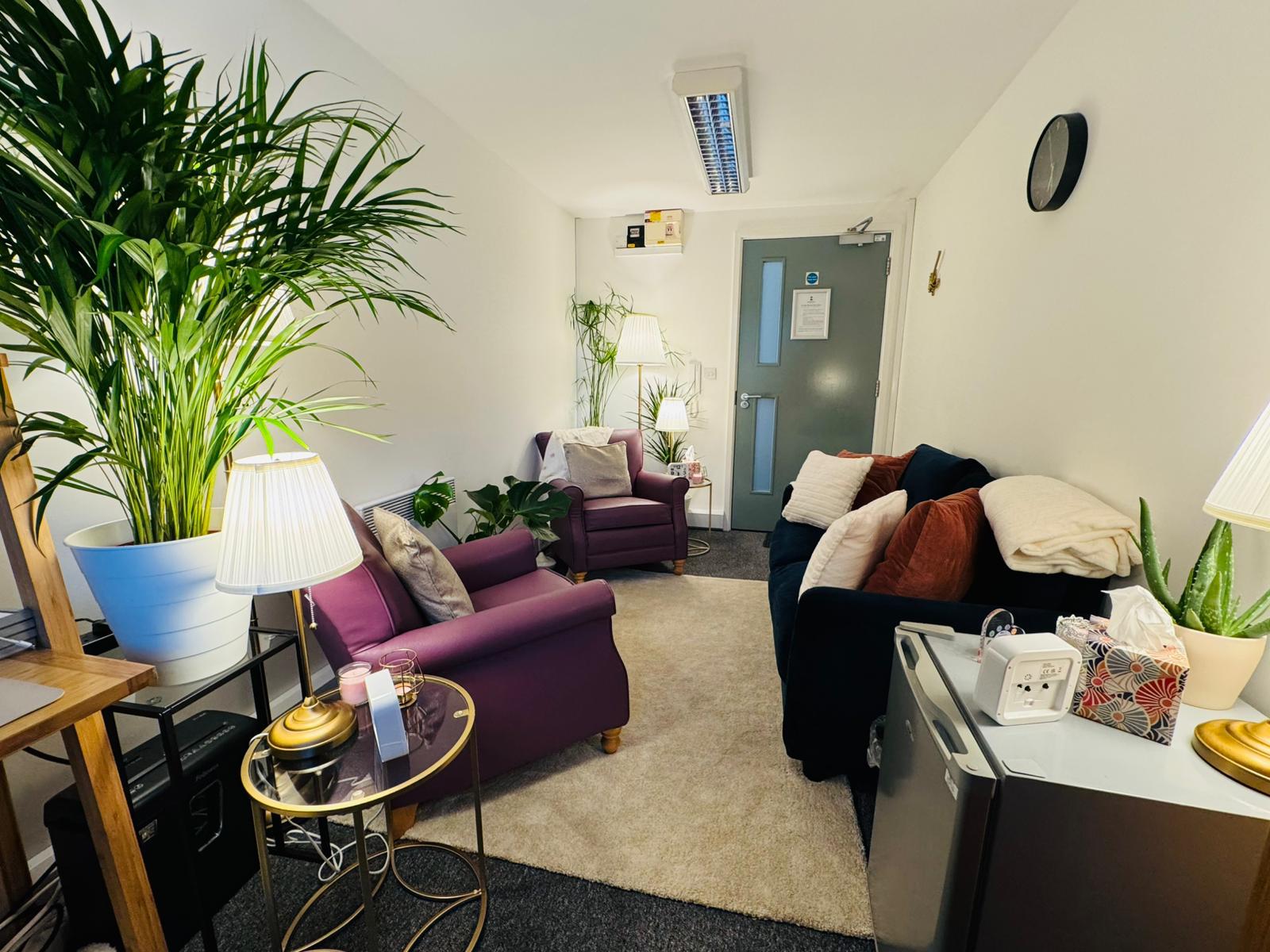 Counselling room with comfortable seating, soft lamp light and plants